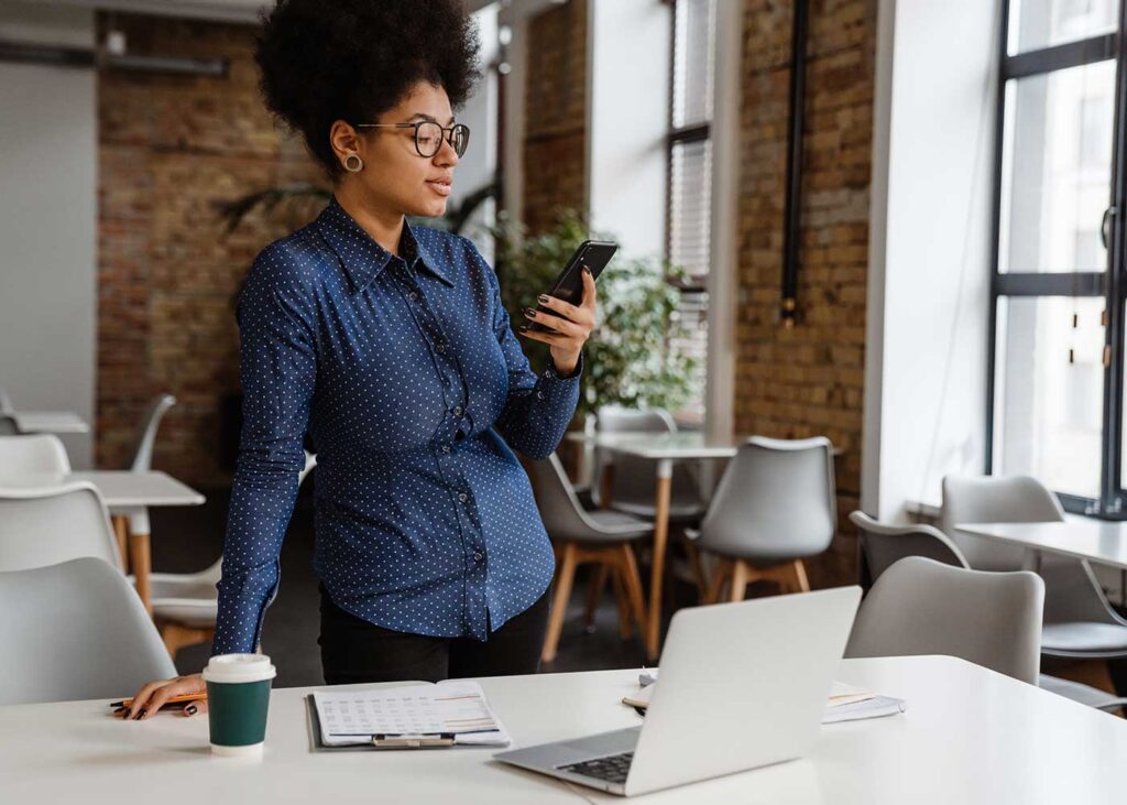 Woman using a phone in an empty classroom