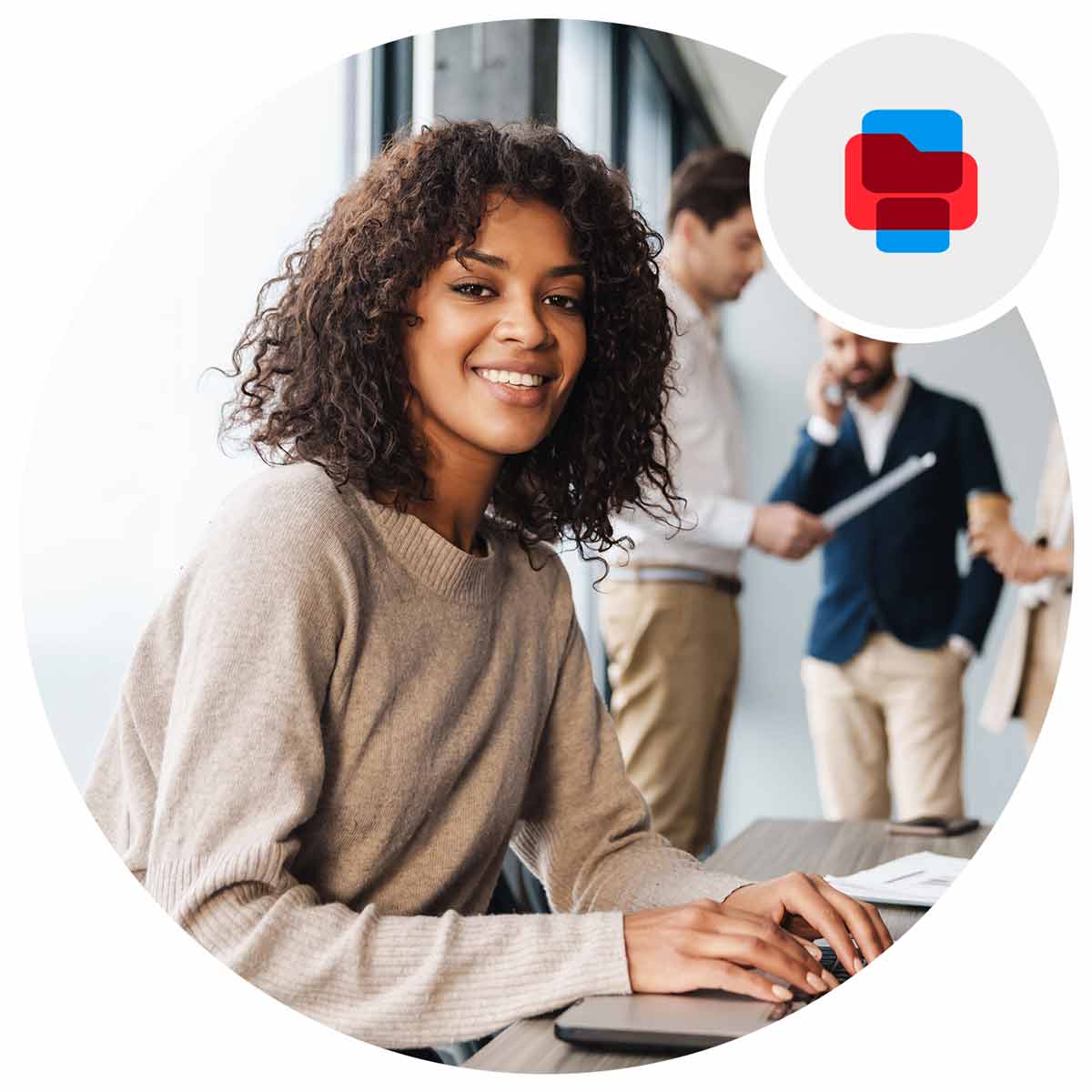 Woman working with a laptop smiling with a group behind her